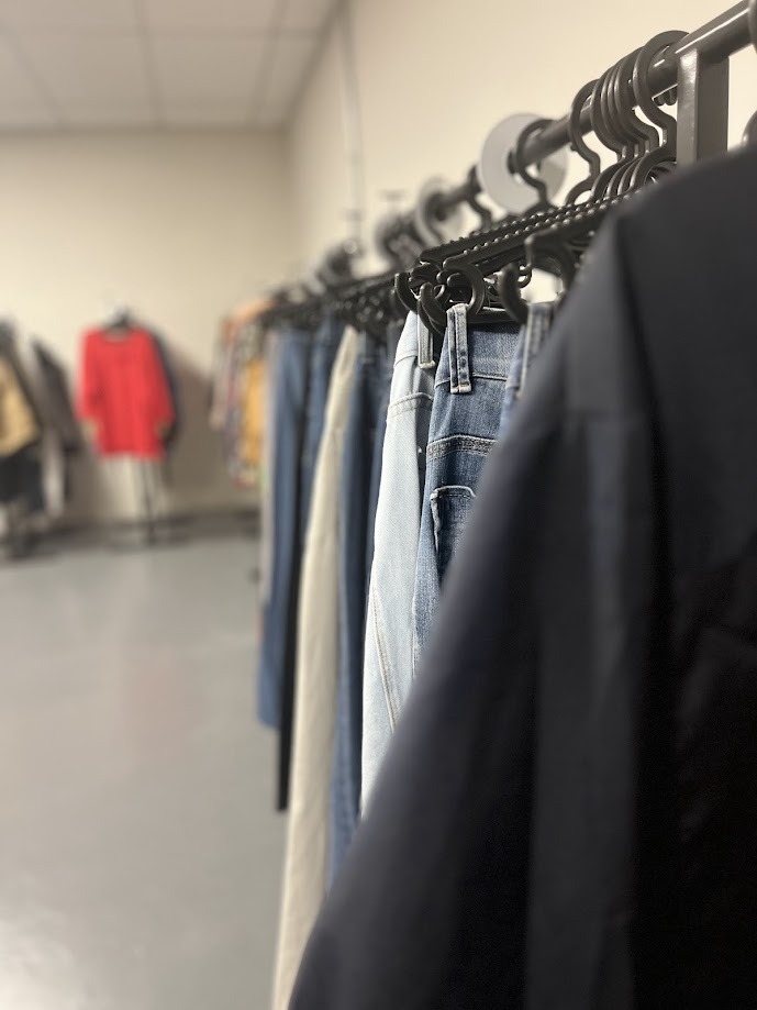 Roupas organizadas em araras no Brechó Solidário